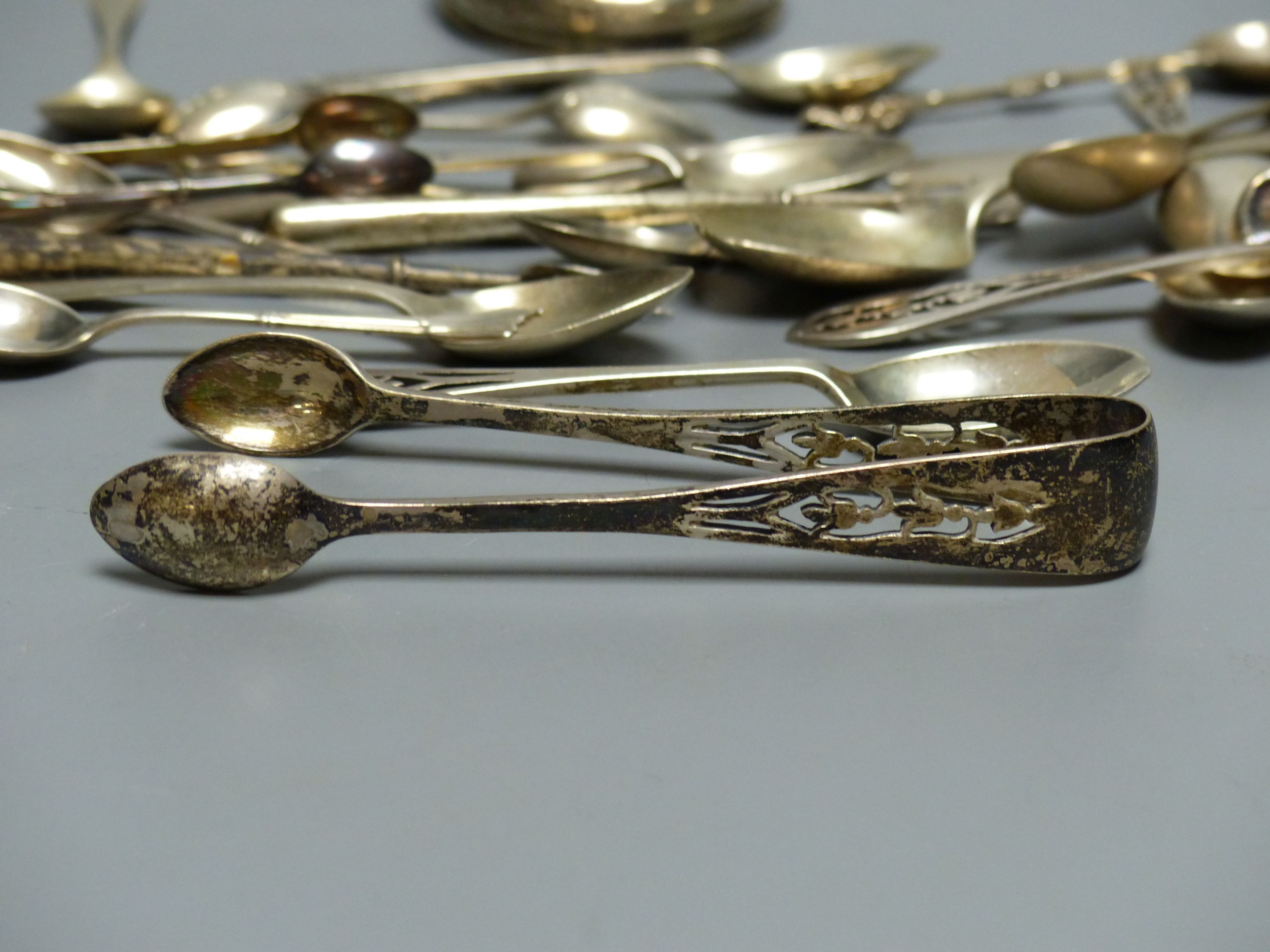 A set of six silver teaspoons and sugar tongs with pierced finials, various other silver spoons, butter knives, etc. (approx 10oz)